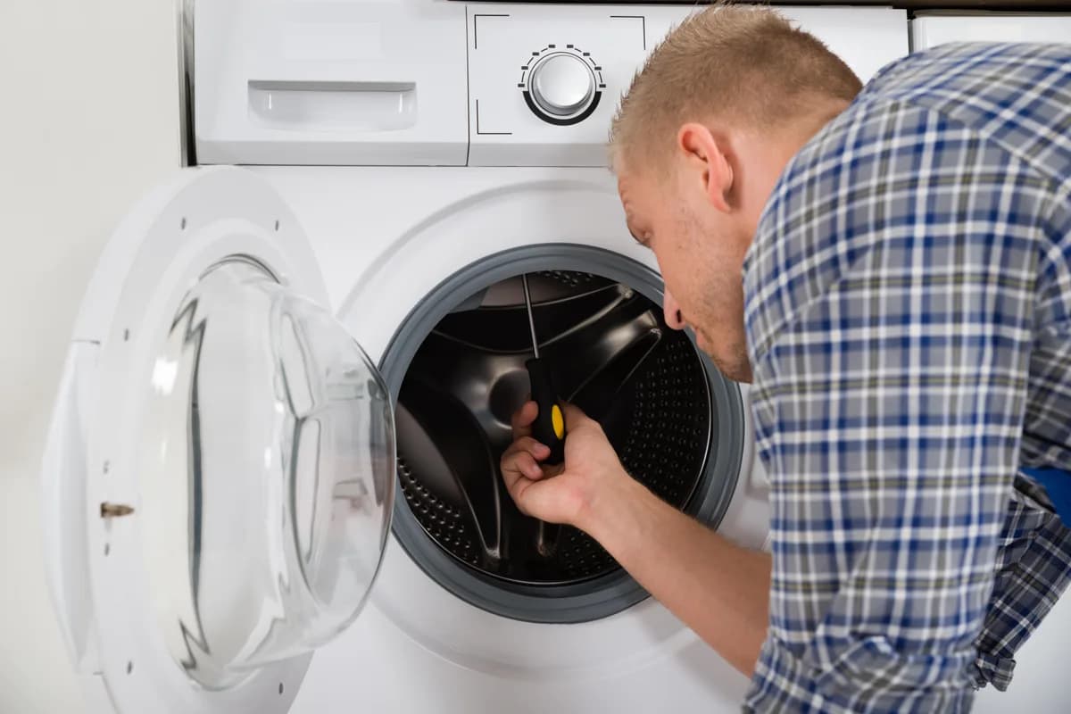 Technician repairing the drum of a front loading washing machine